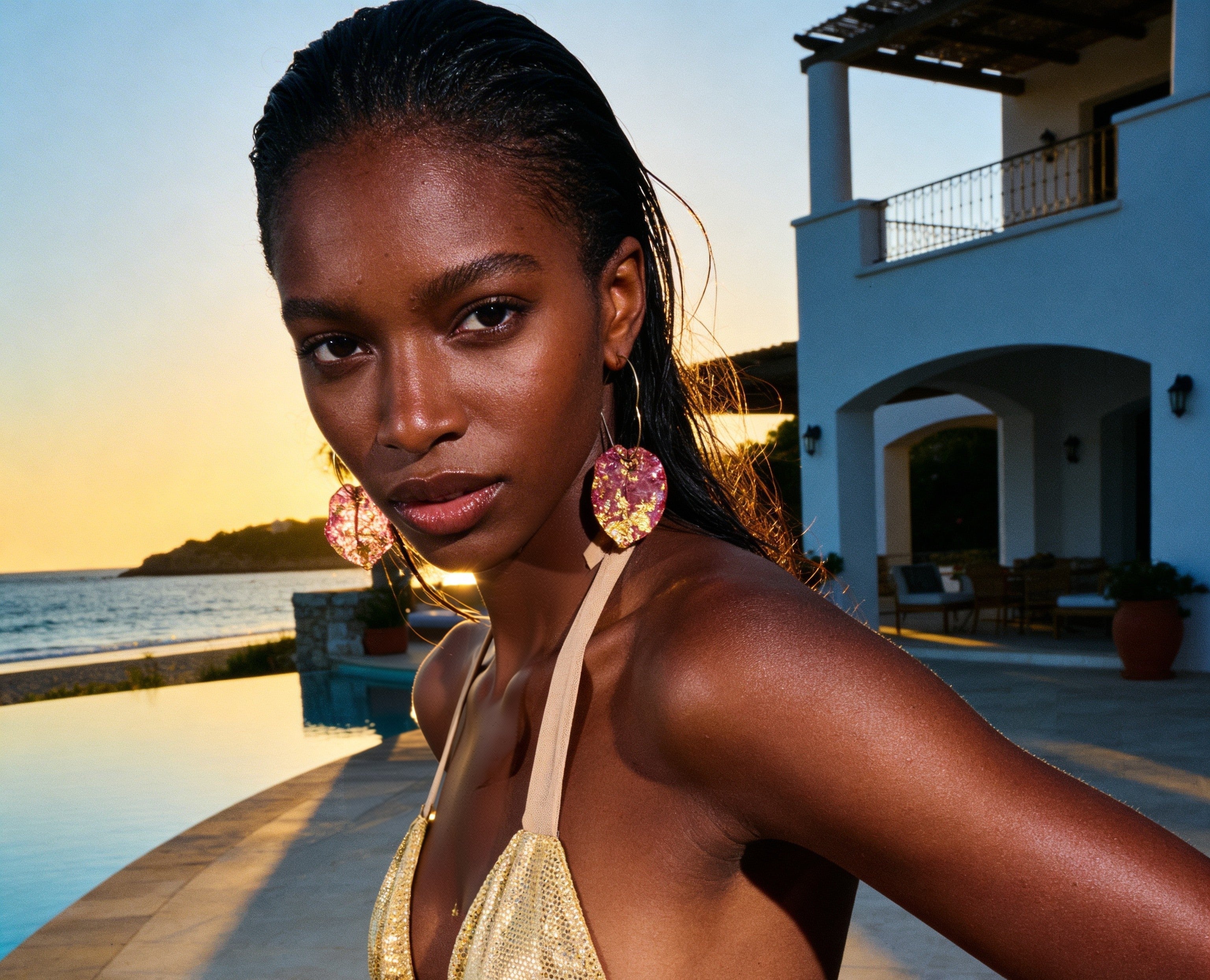 Woman in a yellow bikini standing by a pool with a scenic background